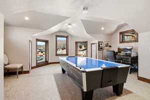 Game room with light colored carpet, lofted ceiling, a desk, and a textured ceiling