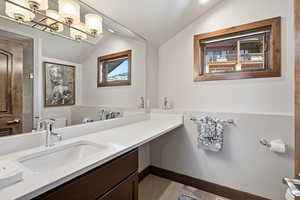 Bathroom with vanity and lofted ceiling