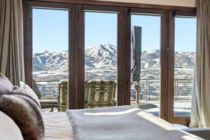 Bedroom with access to outside, a mountain view, and multiple windows