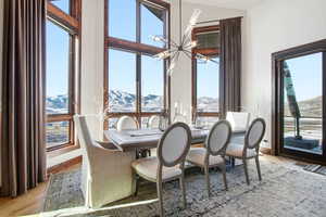 Dining area featuring a chandelier, a mountain view, light wood-style floors, and healthy amount of natural light