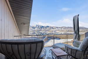 Snow covered back of property with a mountain view
