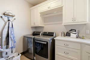 Washroom featuring washing machine and dryer and cabinet space