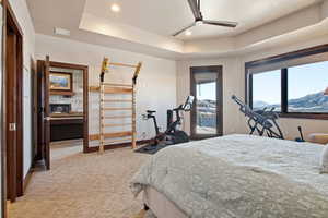 Bedroom featuring a tray ceiling, a ceiling fan, light carpet, recessed lighting, and access to outside
