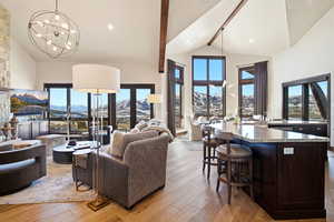 Living room featuring light wood finished floors, a mountain view, healthy amount of natural light, high vaulted ceiling, and recessed lighting