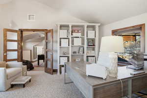 Office space featuring lofted ceiling and carpet