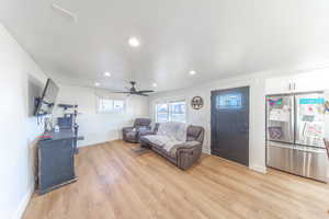 Living room with recessed lighting, light wood-type flooring, ceiling fan, and a textured ceiling