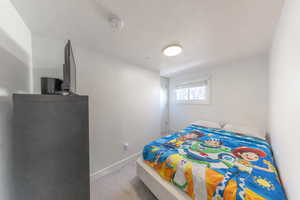 Bedroom featuring light colored carpet and a textured ceiling