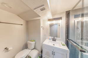 Full bathroom with vanity, a textured ceiling, and a shower stall