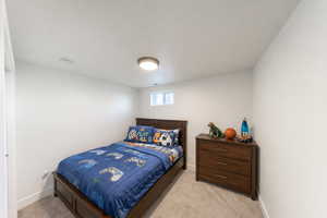 Bedroom with light colored carpet and baseboards