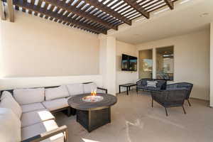 Upper patio with fire pit, hot tub, and TV