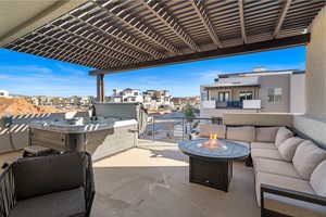 Upper patio with fire pit, hot tub, and TV