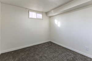 Basement featuring a textured ceiling and dark colored carpet