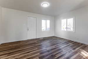 Unfurnished room with dark wood-style floors and a textured ceiling