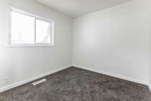 Carpeted spare room with baseboards