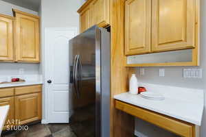 Kitchen featuring stainless steel fridge and light brown cabinetry