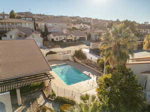 Community pool featuring a patio area, a fenced backyard, and a residential view