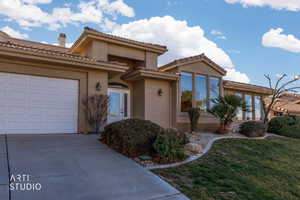 Mediterranean / spanish home with stucco siding, concrete driveway, a front yard, a tiled roof, and a garage