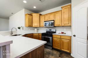 Kitchen with stainless steel appliances, a textured ceiling, light stone countertops, and recessed lighting