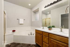 Full bath with a bath, double vanity, and a shower stall