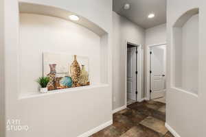 Corridor featuring baseboards and recessed lighting