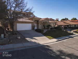 Mediterranean / spanish-style home with driveway, stucco siding, a front lawn, a tiled roof, and a residential view
