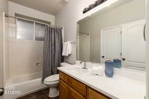 Bathroom with shower / bathtub combination with curtain, vanity, and a textured ceiling