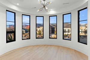 Empty room with light wood-style flooring, healthy amount of natural light, a chandelier, a mountain view, and recessed lighting