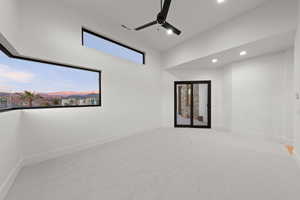 Empty room with a ceiling fan, light colored carpet, and recessed lighting