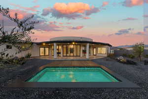 Back of property with a patio, an outdoor pool, and stucco siding