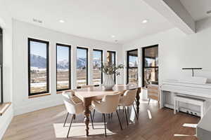Dining space with a mountain view, light wood-style flooring, recessed lighting, and a baseboard heating unit