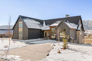 View of front of property featuring stone siding and a chimney