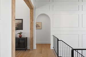 Hall with wood finished floors and arched walkways