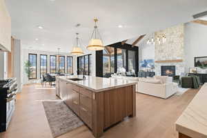 Kitchen with open floor plan, modern cabinets, healthy amount of natural light, range with two ovens, and recessed lighting