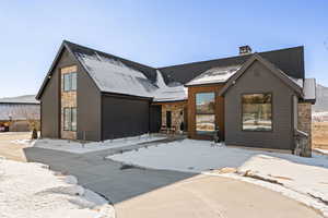 View of front of property featuring stone siding and a chimney