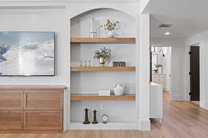 Detailed view of built in shelves, wood finished floors, and recessed lighting