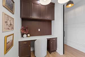 Office space featuring built in study area and light wood-type flooring