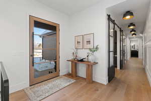 Entrance foyer with a barn door and light wood-type flooring