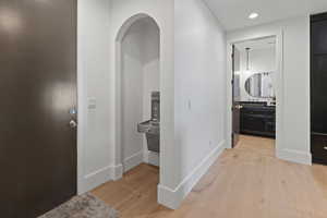 Corridor with light wood finished floors and recessed lighting