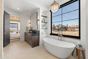 Full bath featuring a freestanding bath, ensuite bath, vanity, and recessed lighting