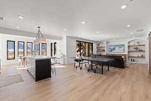 Game room with built in shelves, plenty of natural light, light wood-style flooring, and recessed lighting