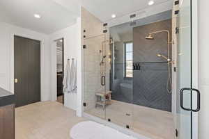 Full bath with a stall shower, a walk in closet, light tile patterned flooring, recessed lighting, and vanity