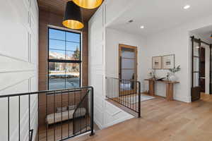 Entryway featuring a barn door, wood finished floors, and recessed lighting