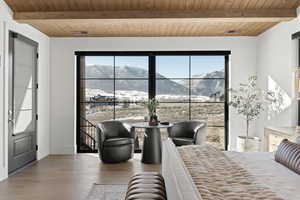 Bedroom with a mountain view, a wood ceiling with exposed beams, and wood finished floors