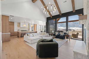 Living room featuring high vaulted ceiling, a mountain view, light wood-style floors, a chandelier, and recessed lighting