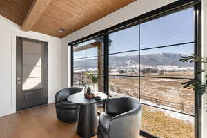 Dining room featuring a mountain view, a wooden ceiling with exposed beams, and wood finished floors