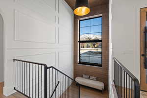 Stairway featuring wood finished floors, arched walkways, and wood walls