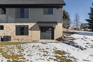 View of front of home featuring roof with shingles, an attached garage, and stone siding