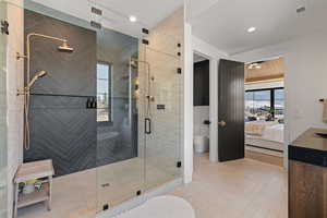 Bathroom featuring connected bathroom, a shower stall, tile patterned floors, vanity, and recessed lighting