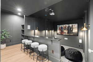 Home theater room featuring baseboards and light wood-type flooring