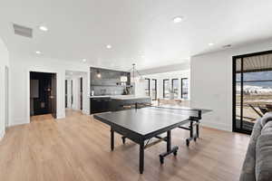 Game room featuring recessed lighting, wet bar, and light wood-style flooring